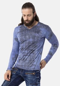 Langärmliges Hemd in einem Farbverlauf von Blau mit einem strukturierten Muster. Verfügt über einen V-Ausschnitt, Knopfakzente und ein Logo auf der Brust. Material aus Baumwollmischung.