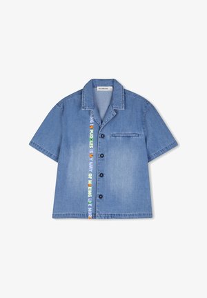 Chemise en jean bleu clair à manches courtes avec fermeture à boutons, poche poitrine et ruban décoratif coloré le long du centre.