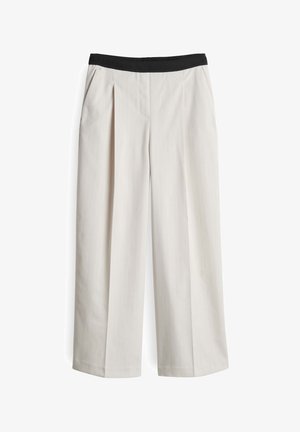 Wijdvallende broek van lichtbeige stof, met een geplooide voorkant en een zwarte elastische tailleband. Soepele textuur met fijne strepen.