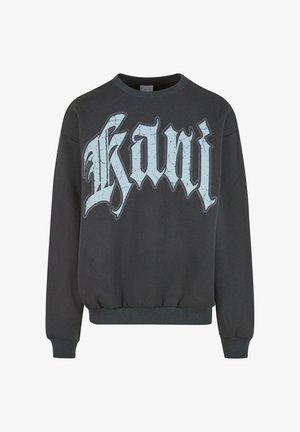 Juodas megztinis su raukšlėmis ant rankovių ir apatinės dalies, su dideliu, įtrūkusiu šviesiai mėlynu tekstu „kani“ gotikos šriftu priekyje.