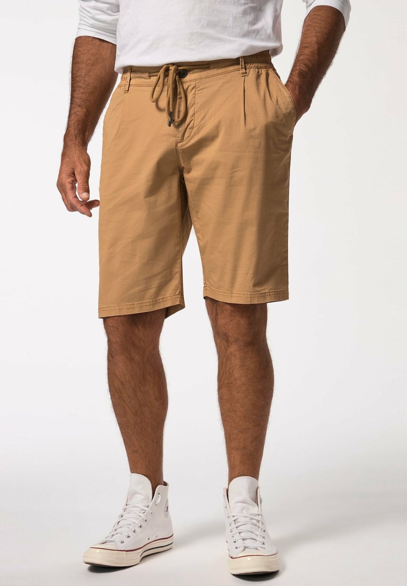 Khaki shorts med elastisk talje og snor, med sidelommer og afslappet pasform. Båret med hvide højhælede sneakers.