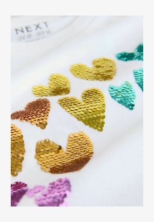 Valge kangas mitmevärviliste kuldsete, türkiissiniste ja roosade litritega südamekujunditega. Litrid on läikivad ja erineva suurusega, luues tekstuuri.