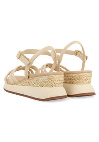 Nude-colored sandals with braided jute wedge heel, round toe, adjustable ankle strap, and soft, textured upper.