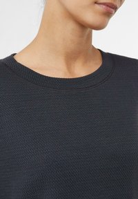 Czarna sweatshirt o teksturowanej powierzchni z okrągłym dekoltem, ribbowym kołnierzem oraz miękkim, grubym materiałem z delikatnym wzorem.