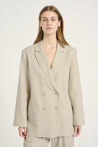 Lichtbeige dubbelzijdige blazer van een linnenmix. Voorzien van een gelapte revers, twee knopen en zijzakken. Soepele textuur.