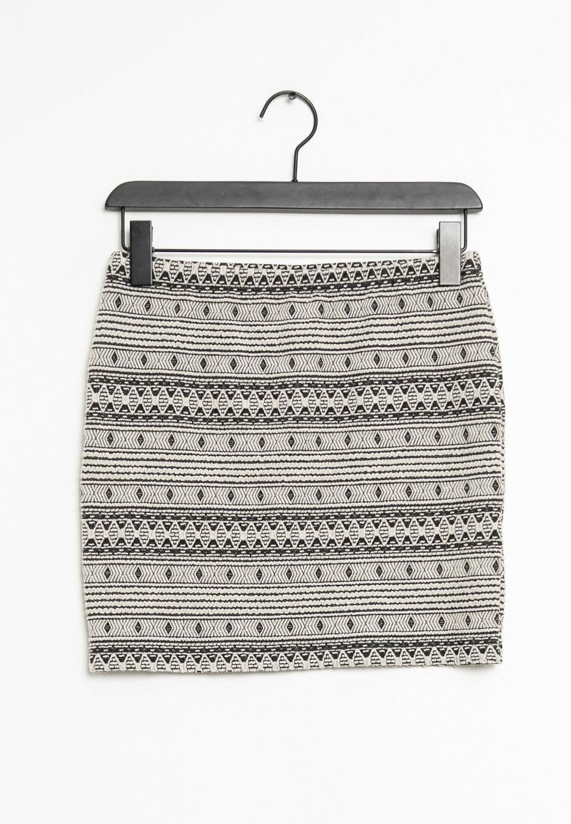Schwarz-weiß gemusterter Rock mit geometrischen Designs, der horizontale Streifen und einen strukturierten Stoff aufweist. Hängt an einem schwarzen Kunststoffhaken.