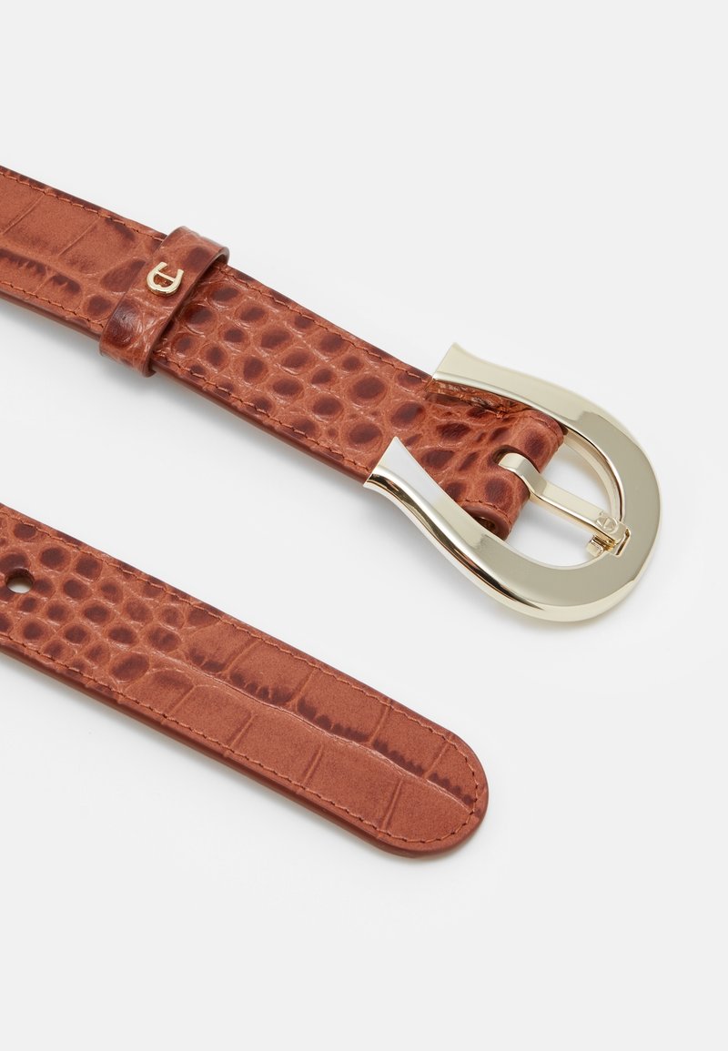 Ceinture en cuir marron à motif crocodile avec boucle incurvée dorée et plusieurs trous pour ajustement.