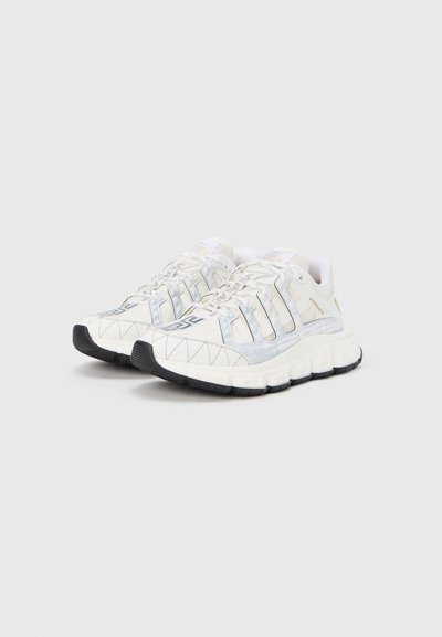 Baltos ir šviesiai mėlynos sportinės avalynės su tekstūruotu viršumi, geometriniu raštu, juodu guminio padais ir raištelių sistema.