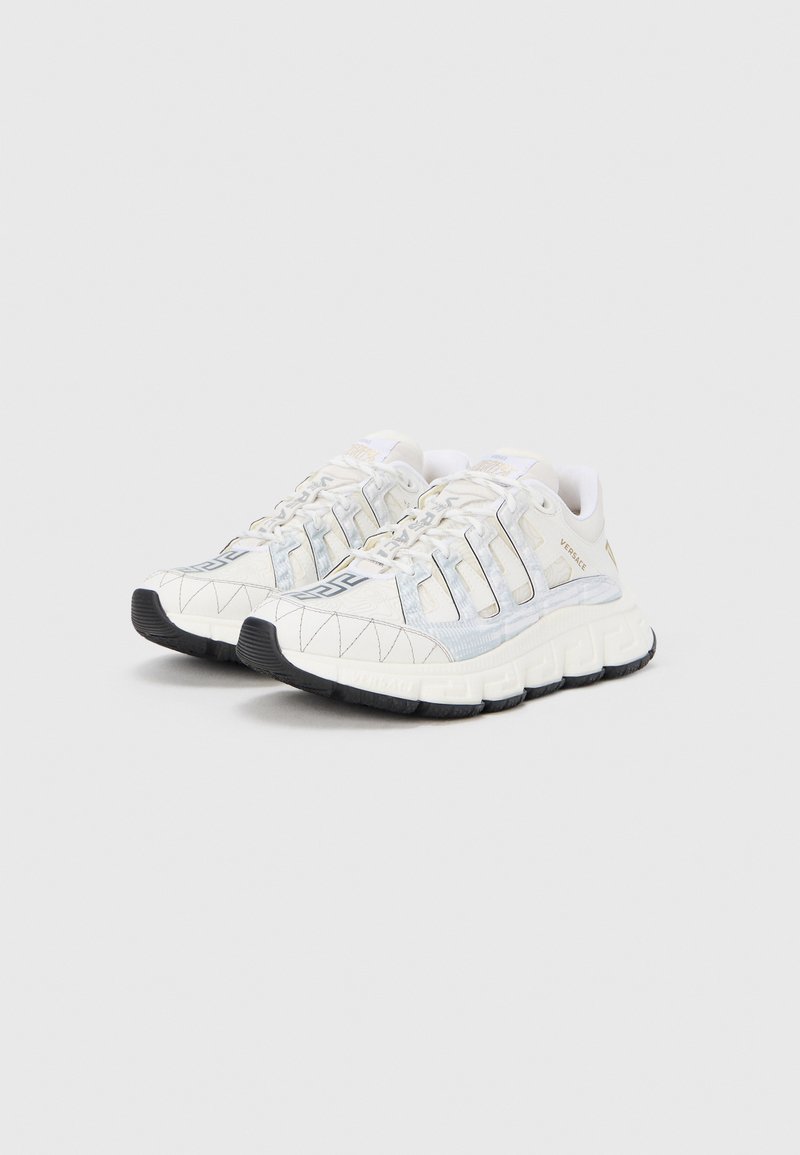 White and light blue athletic shoes with a textured upper, geometric pattern, black rubber sole, and lacing system.