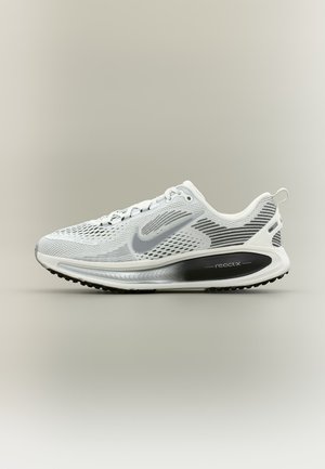 Chaussure de course Nike React blanche et grise avec tige en mesh, semelle accentuée de noir et logo swoosh, présentée de profil sur un fond neutre.