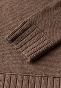 Brauner Strickpullover mit gerippten Bündchen und Saum, strukturiertem Stoff mit weicher Oberfläche und taillierter Form.