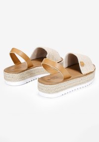 Sandalias cuña con tiras de cuero marrón y una parte superior de tejido beige, con una plataforma de yute texturizada y suela de goma blanca.