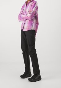 Pink and white plaid long-sleeve shirt, black pants, and black hiking shoes. The shirt features a button-down design and chest pockets.