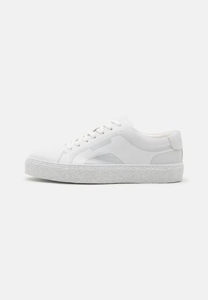 Baskets blanches en cuir avec une semelle en caoutchouc texturée, une finition lisse et de subtils accents gris sur les côtés et la languette.