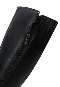 Stivale nero in pelle fino al ginocchio con zip laterale, texture liscia e silhouette strutturata con dettagli di cuciture minime.