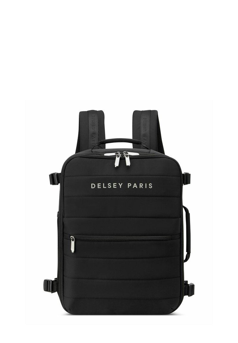 Mochila negra con textura acolchada, correas ajustables, asa superior y acentos de hardware plateado. Logo "DELCY PARIS" mostrado en la parte frontal.