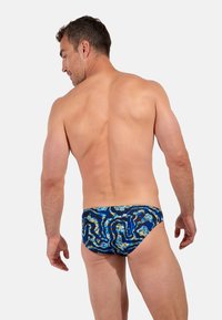 Zwemslips in blauw met abstracte patronen in geel en zwart. Ontworpen met een nauwsluitende pasvorm en een soepele textuur voor comfort.