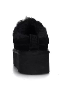 Scarpa nera slip-on con interno peloso, materiale in camoscio, suola piatta imbottita e un piccolo tacco posteriore.