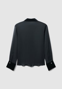 Blusa nera trasparente con maniche lunghe, con colletto in velluto e polsini a contrasto in velluto con dettaglio a bottone. Tessuto liscio e leggero.