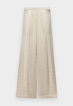 Platus kojinės kelnės kreminės spalvos, su subtiliu geometriniu raštu, tekstūruota medžiaga ir lygiu juosmens apdaila.