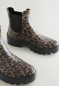 Leopardimustriga kummist pahkluu saapad mattviimistlusega, mustade elastsete paneelide ja tekstureeritud musta tallaga, mis tagab haarduvuse.