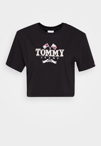 Černé zkrácené tričko vyrobené z bavlny s krátkými rukávy. Obsahuje logo "TOMMY JEANS" s červenými a bílými vlajkami a bannerem se zřízeným rokem.