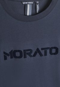 Camiseta de algodón azul marino con cuello redondo, corte regular y la palabra "MORATO" bordada en negrita en color negro en el frontal.