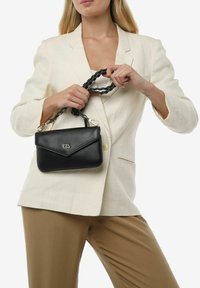 Borsa a tracolla in pelle nera con tracolla a catena intrecciata e hardware argentato. Presenta un cappuccio in stile busta e una superficie liscia e elegante.
