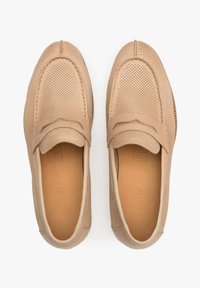 Kožené mokasíny v medové barvě s perforovaným designem, prošívanými detaily a plochou podrážkou. Hladká textura s decentním logem na embosovaném stélce.
