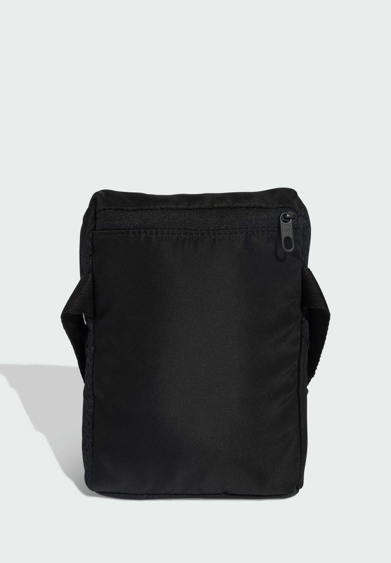 Compacte zwarte crossbodytas met voorvak met rits en verstelbare schouderriem, getoond tegen een effen lichte achtergrond.