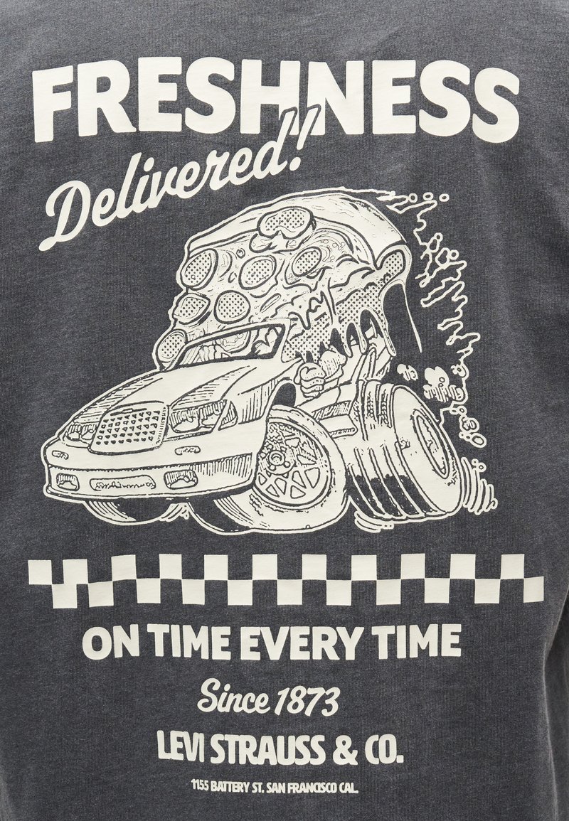 Car shaped like a pepperoni pizza slice with large rear wheels, text reading "Freshness Delivered! On time every time."