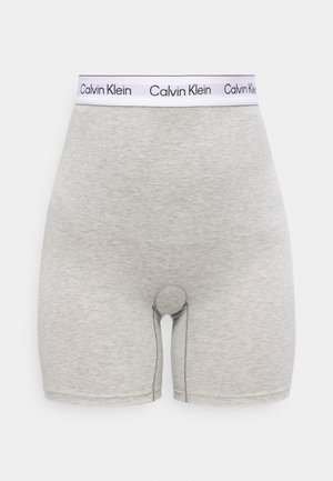 Lys grå herreboxershorts med en hvit elastisk midjebånd med gjentatte svarte "Calvin Klein"-logoer.