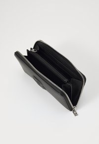 Black leather wallet with a textured surface, zip closure, and multiple compartments for organizing. Silver hardware accents.