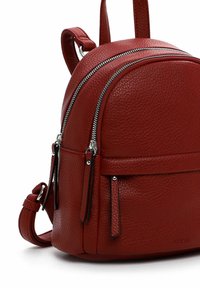 Zaino in pelle rossa con una texture a mosaico, dotato di due scomparti con cerniera, spallacci regolabili e una tasca frontale con tirazip.