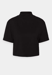 T-shirt court noir avec manches courtes et col montant sur un fond clair uni.