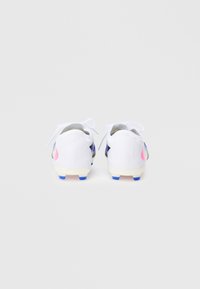 Άσπρα ποδοσφαιρικά παπούτσια με απαλό σχέδιο, που διαθέτουν μπλε και ροζ λεπτομέρειες και υφασμένο τακούνι για καλύτερη πρόσφυση. Τα κορδόνια είναι ορατά στο πάνω μέρος.