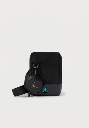 Bolso bandolera negro con un tejido texturizado, diseño elegante y un pouch redondo con cremallera, adjunto con un acento de logo turquesa.
