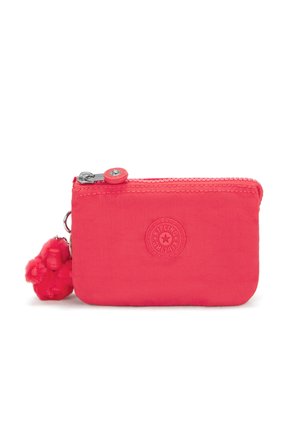 Small pink fabric wallet with a zipper closure, logo embossed on the front, and a fluffy monkey keychain attached.