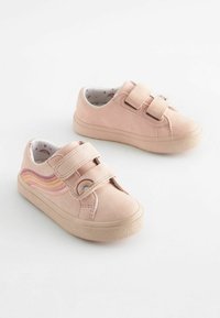 Chaussures en suède rose clair avec deux sangles velcro, motif arc-en-ciel incurvé sur le côté et semelle en caoutchouc texturée. Comprend une doublure intérieure à motif.