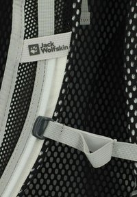 Zwarte mesh rugzakinterieur met grijze banden, een logo-label en een gladde voering met ronde uitsparingen voor ventilatie.