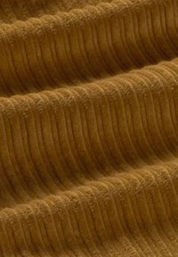Strukturiertes Gewebe in warmem Gelb-Braun mit vertikalen Rippmustern, weicher und plüschiger Oberfläche, die Tiefe und Wärme zeigt.