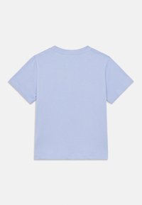 Ανοιχτό μπλε βαμβακερό T-shirt με κοντά μανίκια, στρογγυλή λαιμόκοψη και καθαρές ραφές. Απλός σχεδιασμός χωρίς πρόσθετα μοτίβα ή διακοσμητικά στοιχεία.