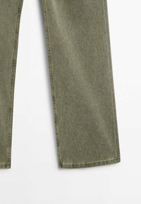 Olivgröna, vida jeans i denim. Har en klassisk femfickorsdesign och synlig sömnad längs sömmarna.