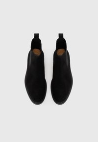 Cizme negre din suede, până la gleznă, cu un finisaj neted, panouri laterale elastice și limbi pentru o îmbrăcare ușoară. Design elegant cu bot rotund.