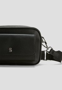 Rechthoekige zwarte leren crossbodytas met voorkantzak, zilveren logo en afneembare strap met metalen clips op een grijze achtergrond.