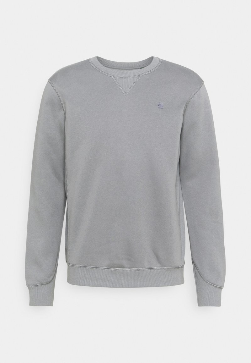 Sweat-shirt gris clair à col rond, manches longues, poignets et ourlet côtelés, avec un petit logo brodé sur la poitrine gauche.
