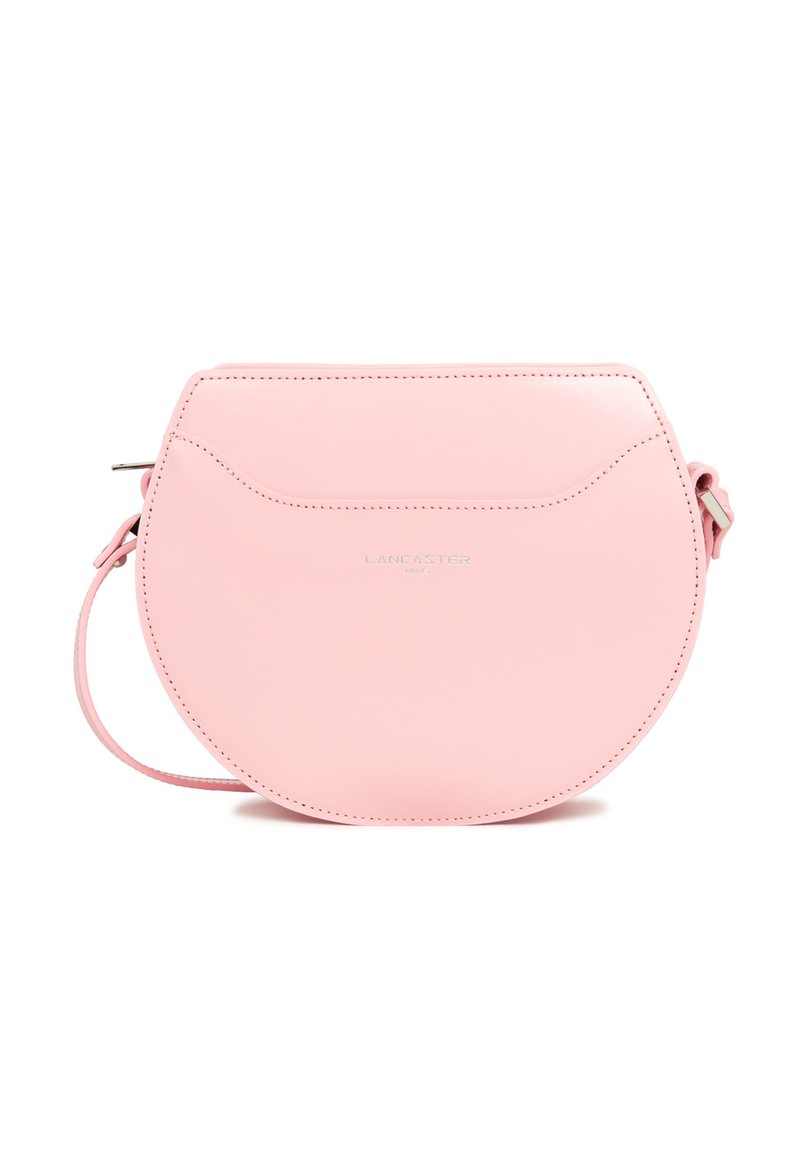 Sac en cuir rose rond à bandoulière avec une fermeture éclair, détails de couture subtils et une sangle ajustable. Présente un petit logo sur le devant.