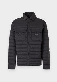 Veste matelassée noire avec fermeture complète à boutons sur le devant, deux poches poitrine à rabat et col, avec petit logo blanc Armani Exchange sur la poche droite.