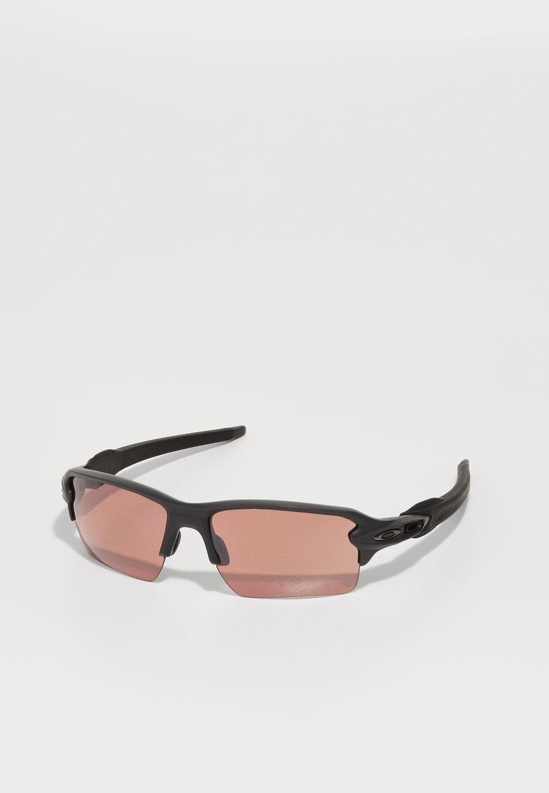 Zwarte zonnebril met roze lenzen. Heeft een sportief ontwerp, stevig plastic frame en gestructureerde armen voor grip. Geen zichtbaar logo of patroon.