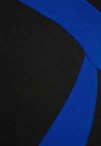 Černá látka s hladkým povrchem, která má modrý diagonální pruh. Tento design vytváří kontrast mezi barvami a tvary.